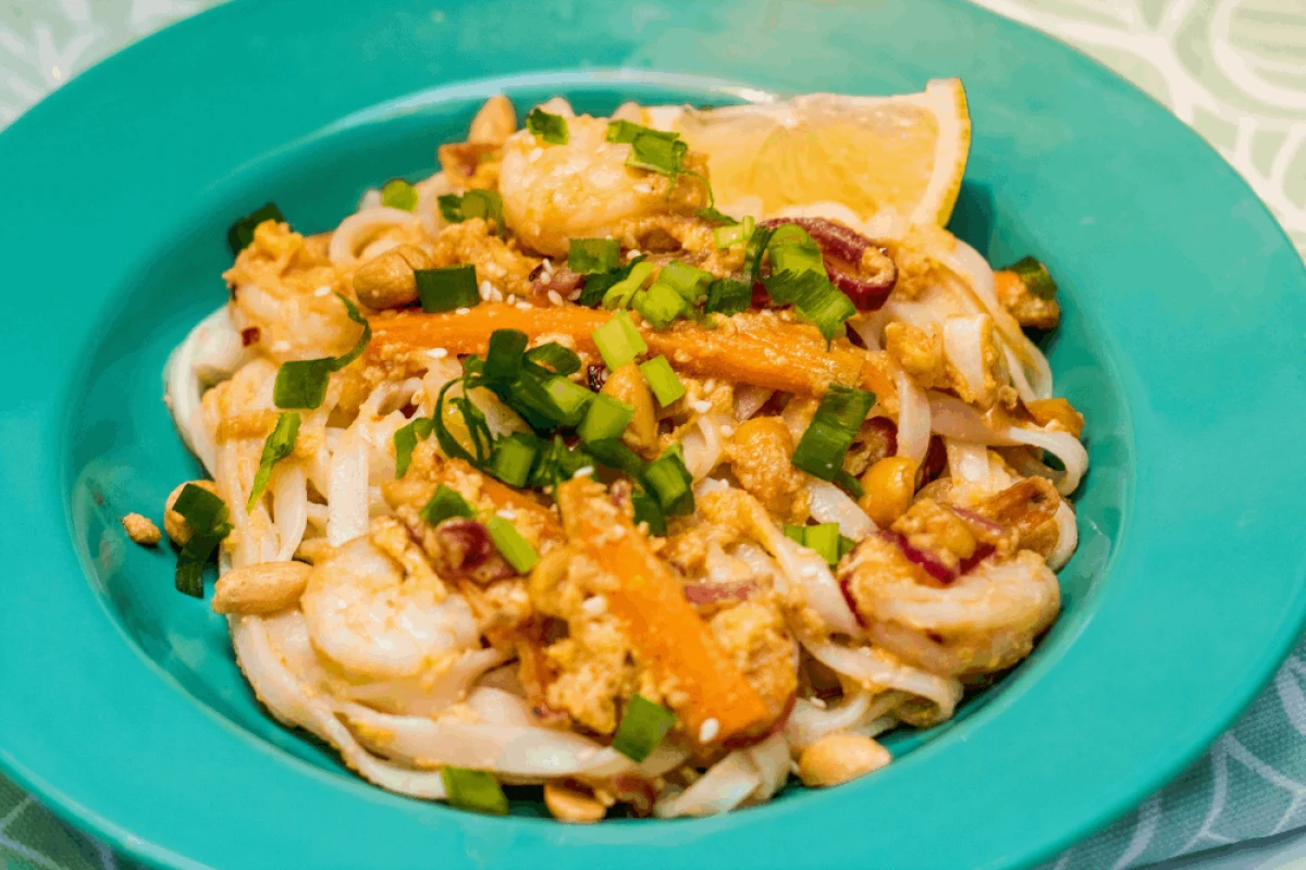 Makaron ryżowy z kurczakiem i kolorowymi warzywami po tajsku na turkusowym talerzu